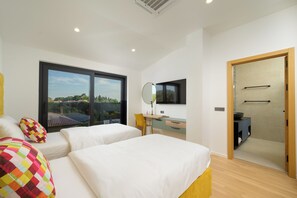 Une chambre moderne avec deux lits, un bureau et une grande fenêtre donnant sur la ville.