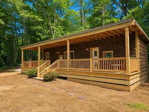 A log cabin with a wooden deck and multiple windows.
