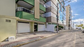 A multi-story building with a green and beige facade, a gated entrance, and a clear sky. - Apt With Balcony & BBQ 78m From the Beach Obs0101 (Itapema)