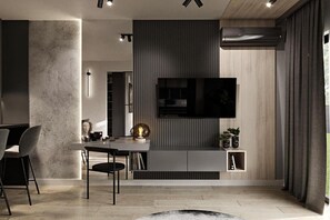 A modern living room with a flat-screen TV mounted on a wall, a dining area with a table and chairs, and a large window with curtains. - A Comfortable Apartment in the Center of Lodz (Łódź)