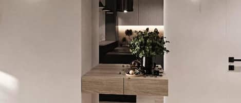 A modern interior with a wooden floor, a plant, and a minimalist design.
