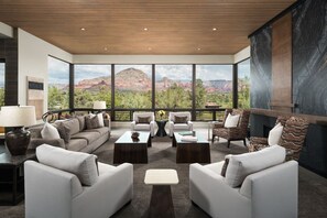 A modern living room with a large window overlooking a mountainous landscape. - Signature Designer Home | Views, Wellness, Games (Sedona)