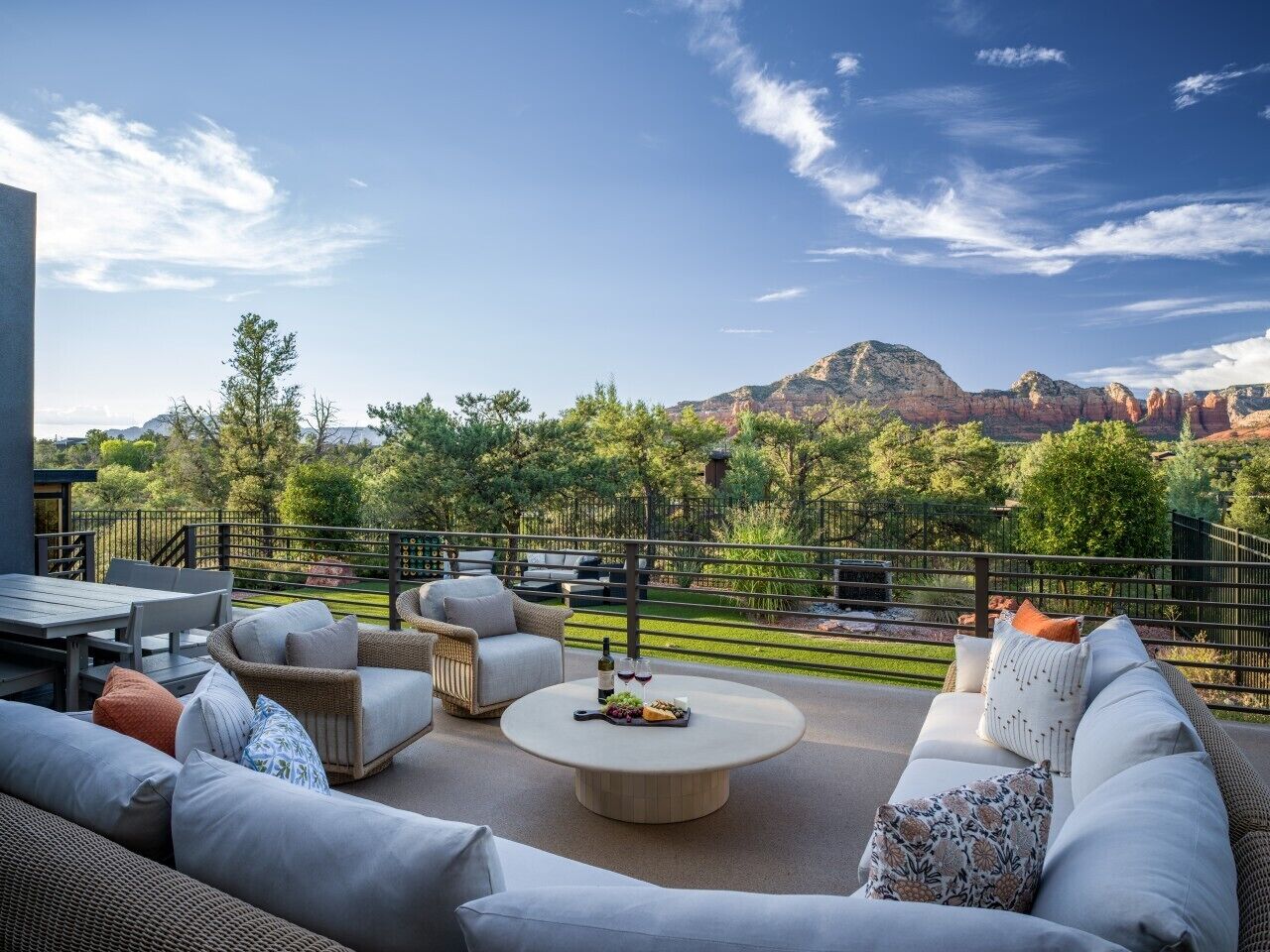 Eine Terrasse mit Gartenmöbeln, einem Esstisch und Blick auf die Berge.