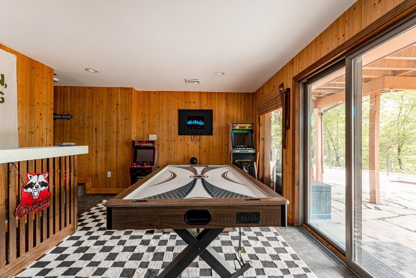 Een biljarttafel in een kamer met houten wanden en een geruit vloertje.