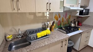 A kitchen with a sink, stove, microwave, and cabinets. - Beautiful 2-bedroom apartment perfect for a relaxing getaway. (Wanchaq)
