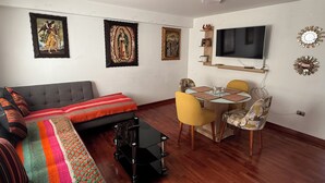 A living room with a sofa, a coffee table, and a dining area with chairs and a table. - Beautiful 2-bedroom apartment perfect for a relaxing getaway. (Wanchaq)