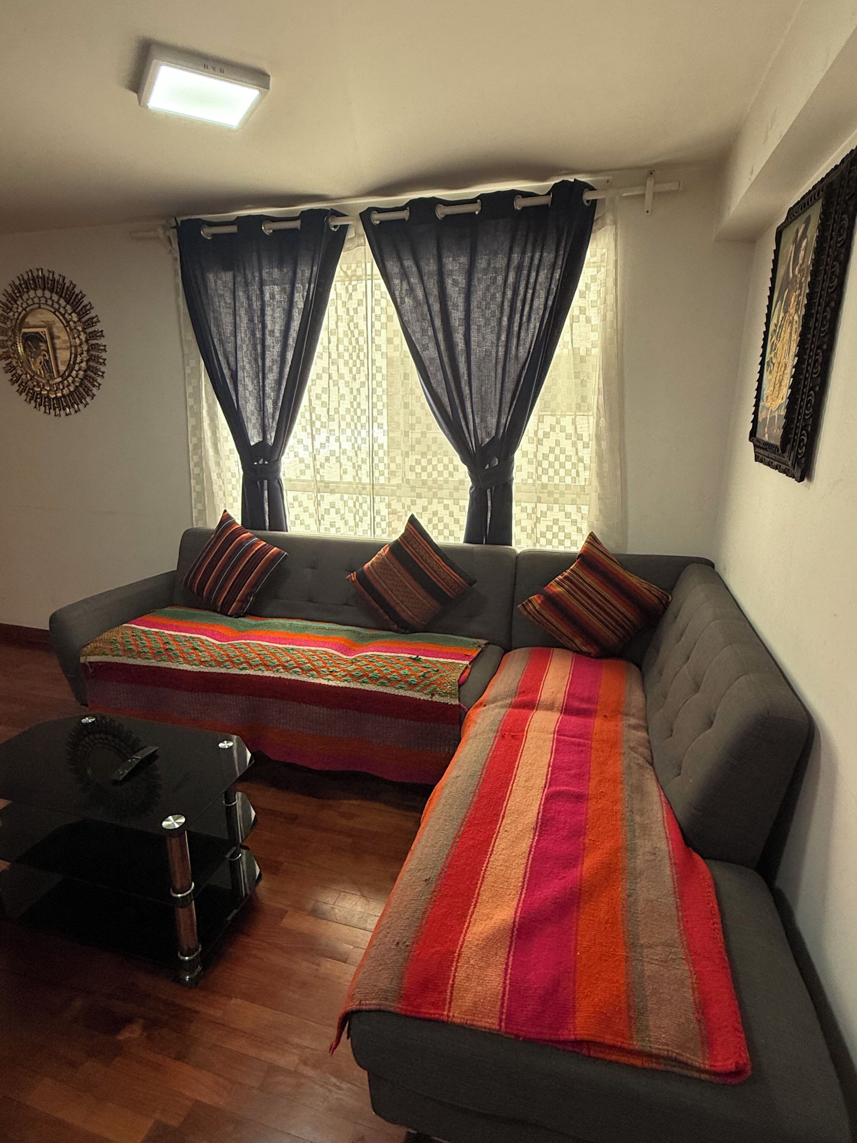 A living room with a sofa, a coffee table, and a patterned rug.