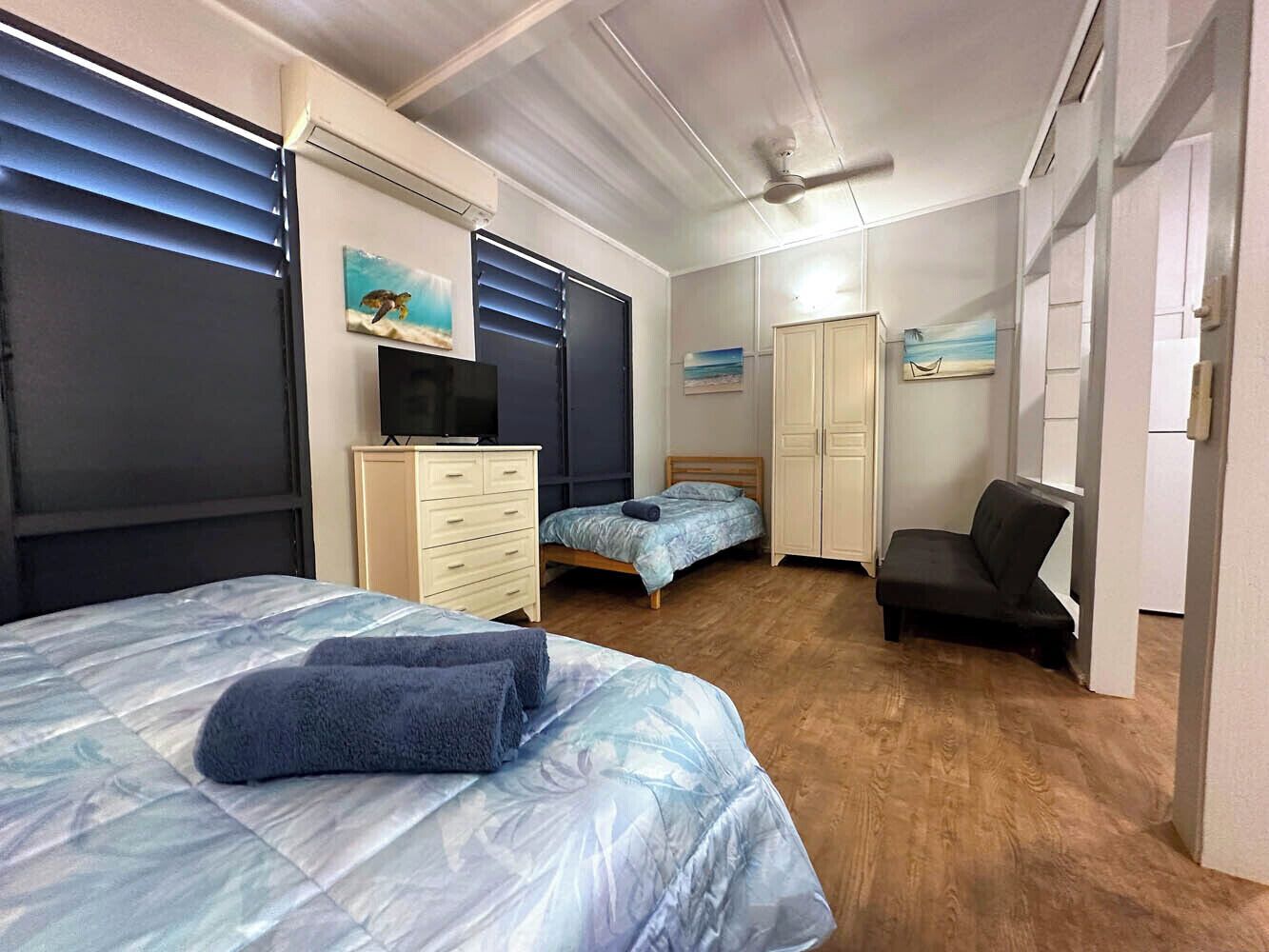 A bedroom with a bed, a dresser, a desk, a chair, and a wardrobe.