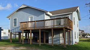 Ein zweistöckiges Haus mit einer Holzterrasse und einer Garage.