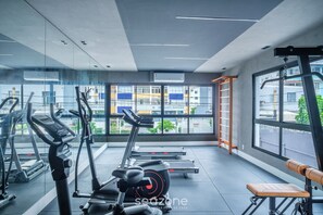 A modern gym with treadmills, stationary bikes, and a bench. Large windows provide views of buildings outside. - Modern Studio w/ Pool 450m From the Beach Prv1003 (Salvador)