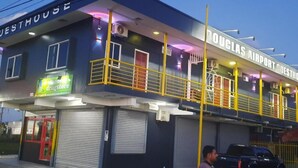 Un edificio con un letrero que dice 'Douglas Airport Guesthouse' y un rótulo de 'farmacia'.
