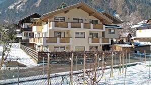 Ein mehrstöckiges Hotel mit Balkonen vor einer Bergkulisse.