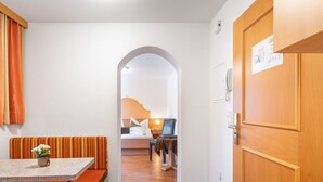 Ein Hotelzimmer mit einer Küchenzeile, einem Essbereich mit einer Bank und einem Bett mit einem Nachttisch.