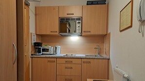 Eine kleine Küchenzeile mit Mikrowelle, Toaster, Kaffeemaschine und Spüle.