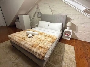 Ein Schlafzimmer mit einem Bett, einem Nachttisch, einer Lampe und einem weißen Kleiderschrank.