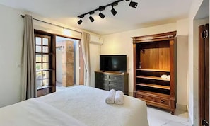 A hotel room with a bed, a television, a wardrobe, and a door leading outside. - Apt w Jacuzzi & Garden 350m From the Beach Psn002 (Itajai)