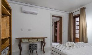 Ein Schlafzimmer mit Bett, Schreibtisch, Stuhl und Kleiderschrank.