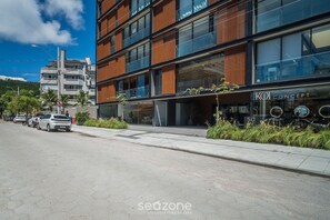 Ein modernes Gebäude mit einer Schaufensterfront, auf der „Patio Jurere“ und „KOI Concept“ stehen.