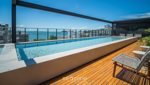Ein Pool auf dem Dach mit Blick auf das Meer und die Gebäude.