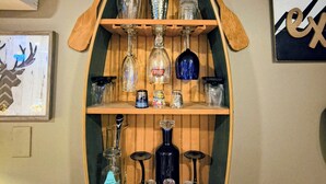 A wooden shelf with various glassware and bottles. - Prescott Spirits: A bar themed getaway, 7 minute drive to historic Whiskey Row (Prescott)