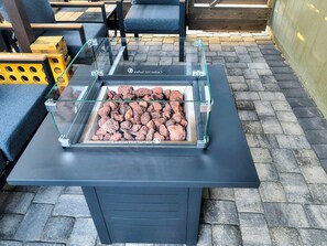 Une enceinte en verre, munie d’une étiquette d’avertissement, contenant ce qui ressemble à des pierres chauffées, posée sur une table noire à ossature métallique.