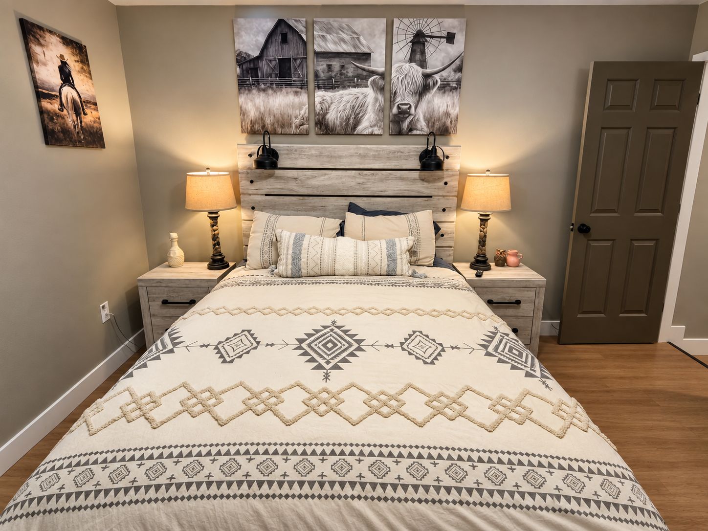 A bedroom with a bed, two bedside tables, a door, and wall art.
