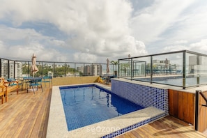 A rooftop pool area with a blue-tiled pool, wooden deck, and outdoor seating. - 2-bedr ap 400 m the sea in a Cond. W/gym Pzo0905 (Ilhéus)