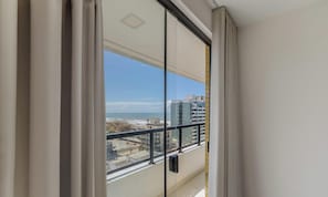 Uma varanda com vista para a praia e edifícios.