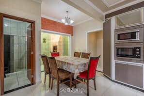 A dining area with a round table, chairs, and a built-in oven. - House With Barbecue and 2 Bedrooms Rek0001 (Penha)