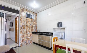 Una cuina moderna amb un respatller estampat, un forn de microones integrat i una cuina a gas.