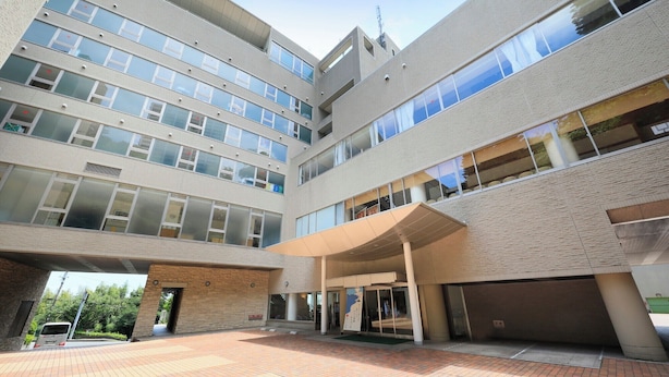 A multi-story building with a covered entrance and a parking area. - KKR Hotel Atami (Atami)