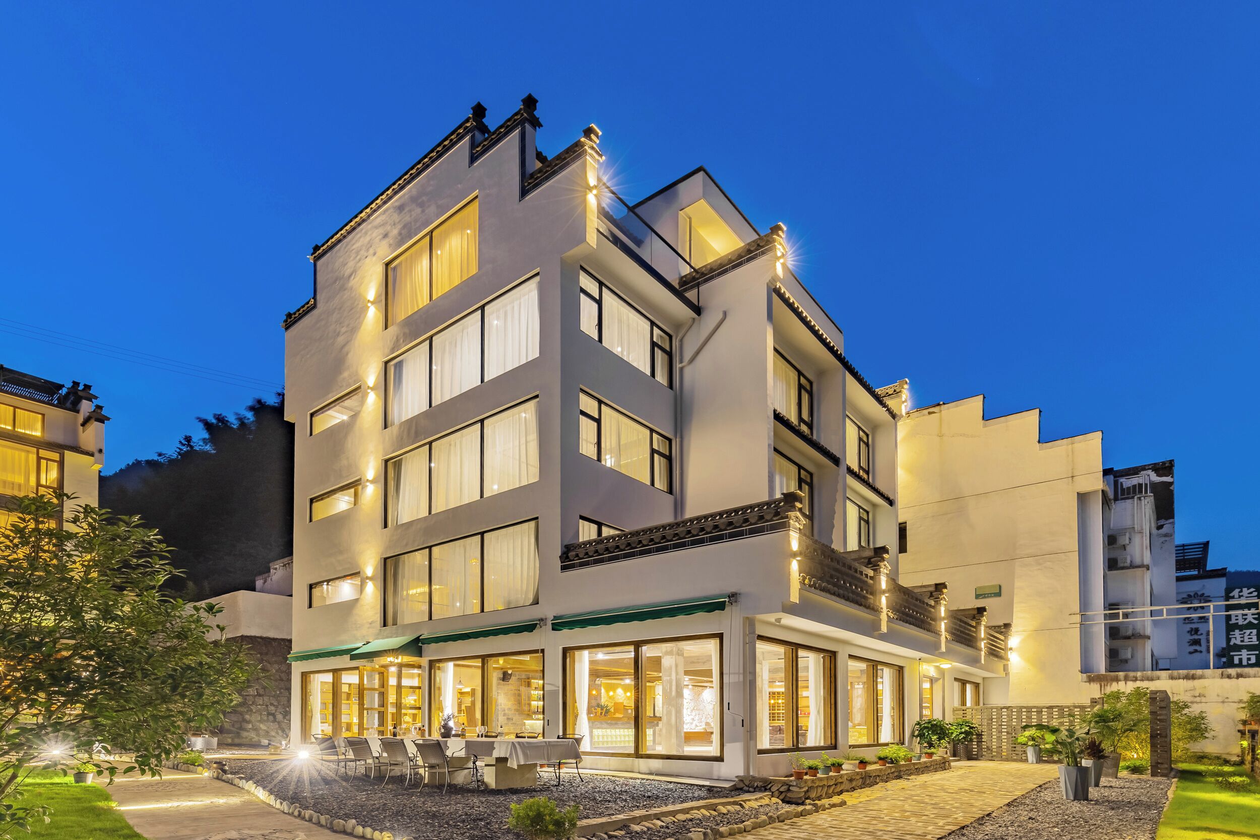A multi-story hotel with a ground-level restaurant and outdoor seating.
