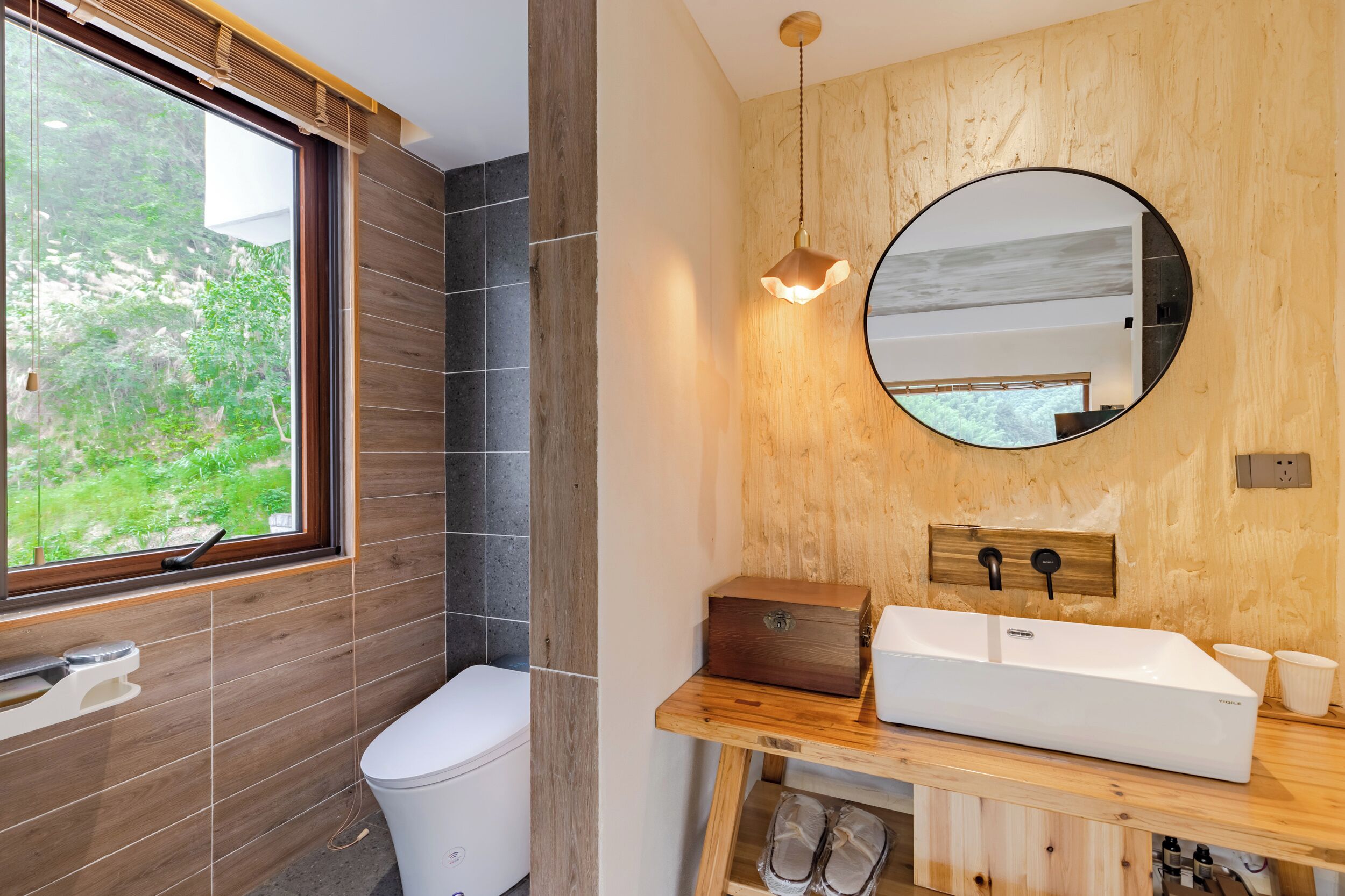 Un baño moderno con tocador de madera, lavamanos blanco y un espejo grande.