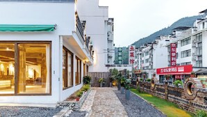 A hotel with a modern facade, a visible entrance, and a pathway leading to the entrance. - Mount Huangshan Wen'an B&B (Huangshan)