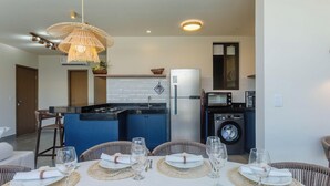 Una cocina compacta con estufa integrada, refrigerador y microondas.