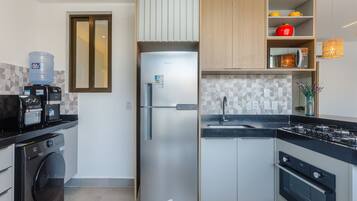 A modern kitchen with a stainless steel refrigerator, built-in oven, and a water dispenser.
