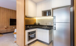 A modern kitchen with a built-in oven, a stainless steel refrigerator, and a microwave above the stove. - Modern apt w/ 3 Suites 350m From the Beach Bbc0004 (Maraú)