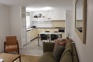 A compact living space with a kitchenette, dining area, and a sofa.