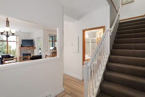 A staircase with a carpeted landing and a white railing.