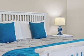 A bed with a headboard, a bedside table with a lamp, and a blue and white patterned bedspread. - 2BR/2BA Branson condo with king beds, pool, hot tub, and balcony. (Branson)