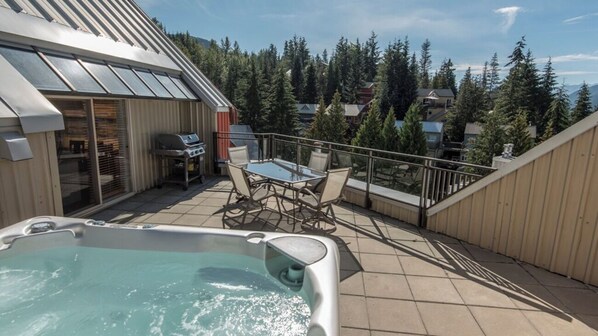 A rooftop patio with a hot tub, outdoor furniture, and a grill. - Whistler Creekside Retreat | Ski-In/Out Condo w/ Heated Pool & Hot Tub (Whistler)