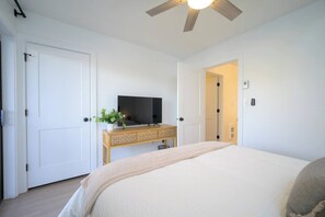 A bedroom with a bed, a television on a wooden console, and a ceiling fan. - 2BR Mountain Condo | Community Pool & Hot Tub (Eden)