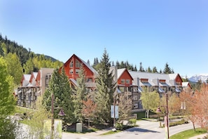 A hotel with multiple red-roofed buildings, surrounded by trees and a mountain backdrop. - Whistler Escape | Spacious Oasis w/ Mountain Views | Winter Outdoors (Whistler)