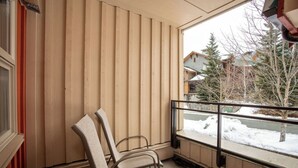 A room with a large window, wooden blinds, and two chairs. - Whistler Escape | Spacious Oasis w/ Mountain Views | Winter Outdoors (Whistler)