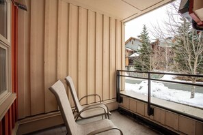 A room with a large window, wooden blinds, and two chairs. - Whistler Escape | Spacious Oasis w/ Mountain Views | Winter Outdoors (Whistler)