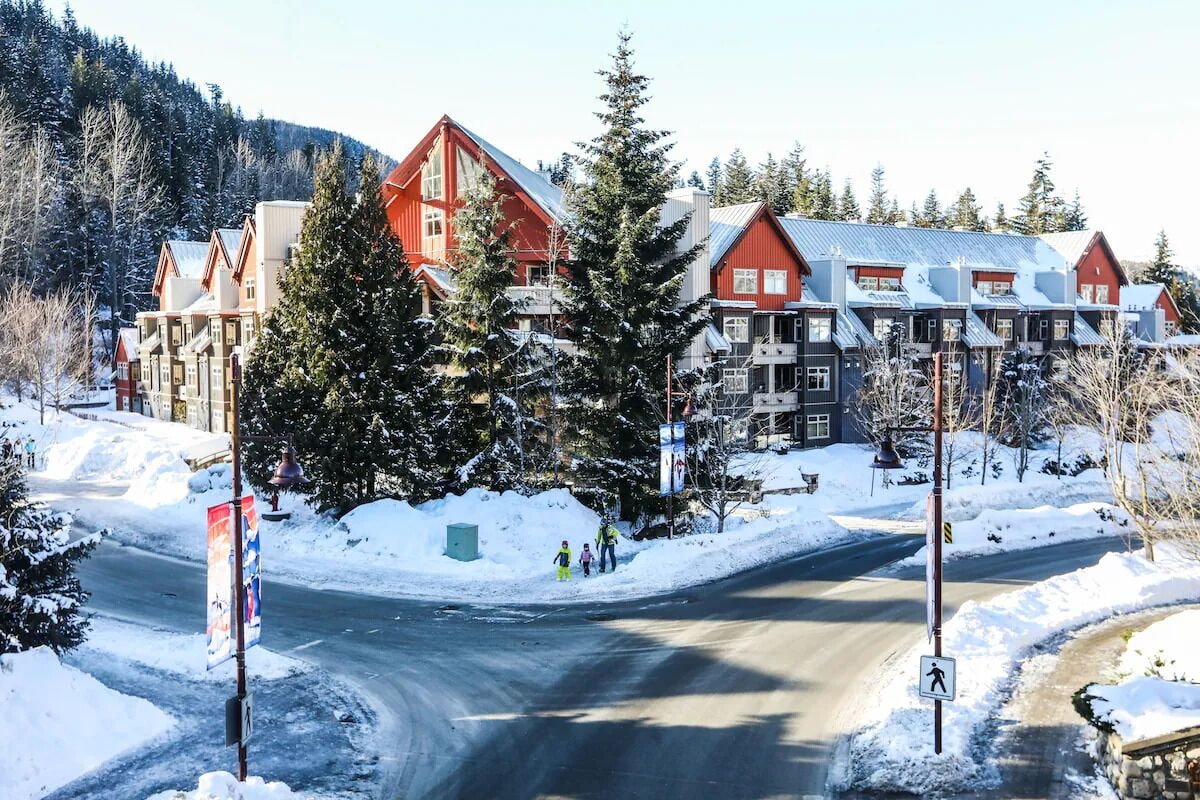 Eine schneebedeckte Straße mit Gebäuden im Hintergrund.