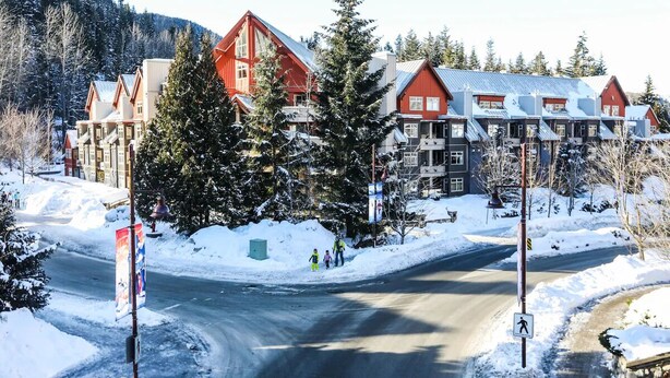 Eine schneebedeckte Straße mit Gebäuden im Hintergrund.