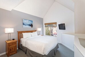 A bedroom with a bed, bedside tables, a window, and a television. - Whistler Creekside Stay | Modern Kitchen & Scenic Views | Near Gondola (Whistler)