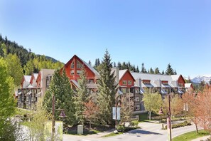 Ein Hotel mit mehreren Gebäuden mit roten Dächern, umgeben von Bäumen und einem Berg im Hintergrund.