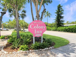 Ein pinkes Schild für Colony Inn mit einer Telefonnummer.